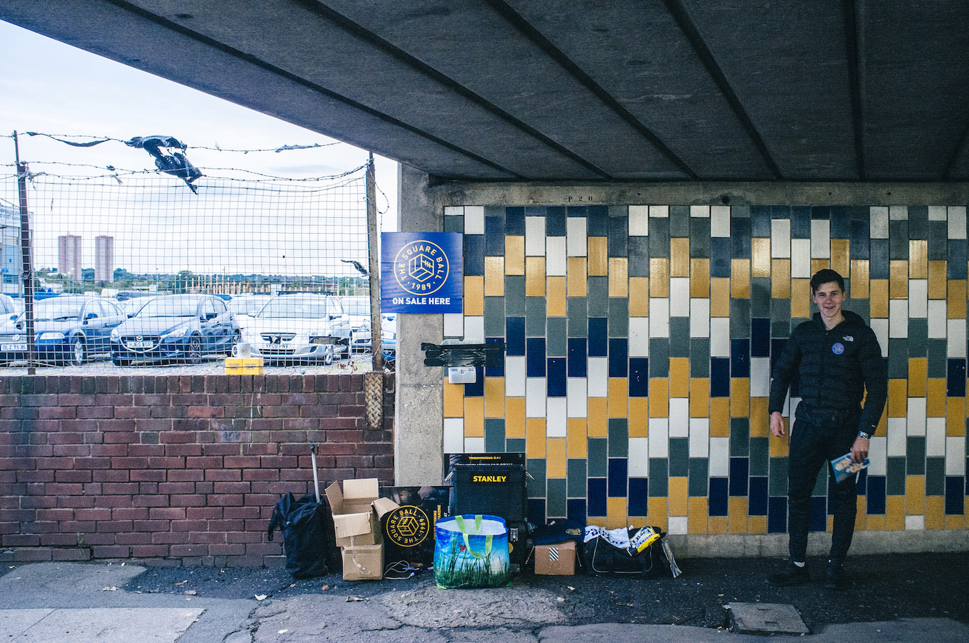 Issues of The Square Ball on sale outside Elland Road. The logo can also be seen on a poster affixed to a fence.